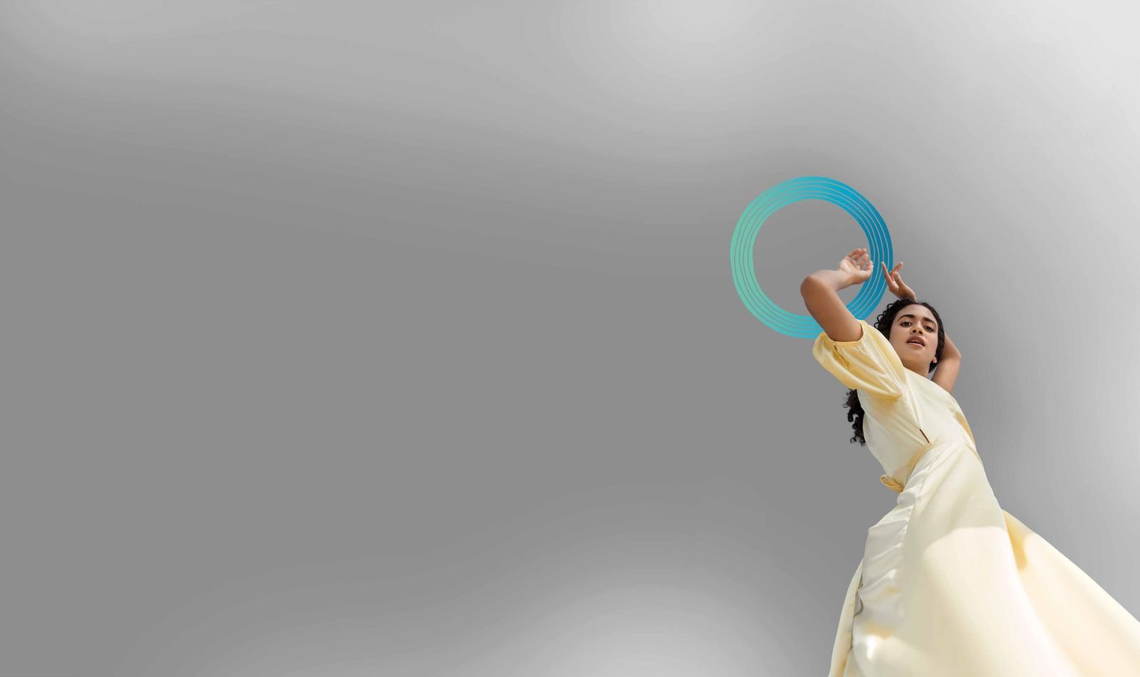 Editorial portrait reaching toward the teal Niva sun ring, the brand symbol of Signum Niva Kolkata